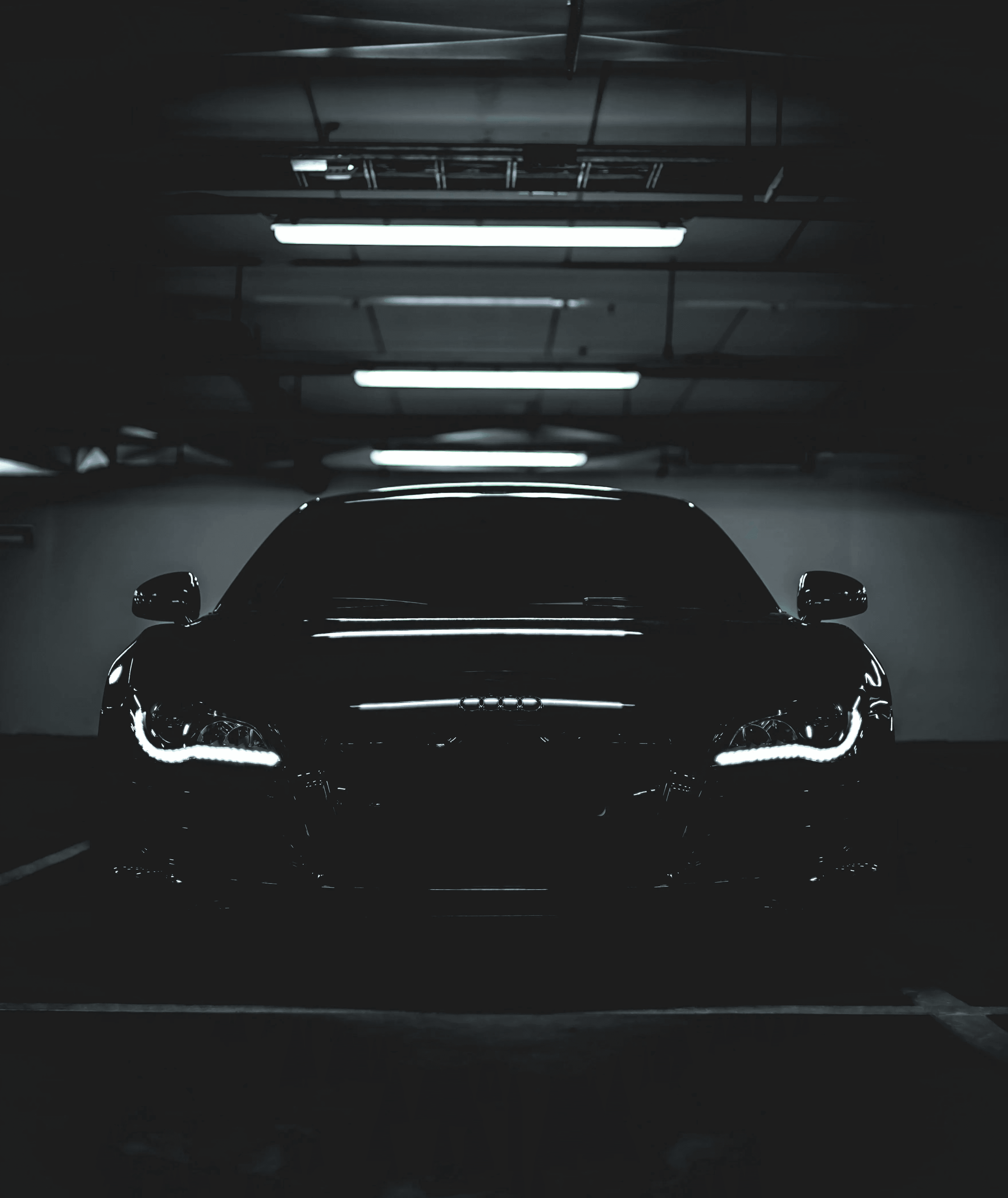 Front view, black car in a dark garage