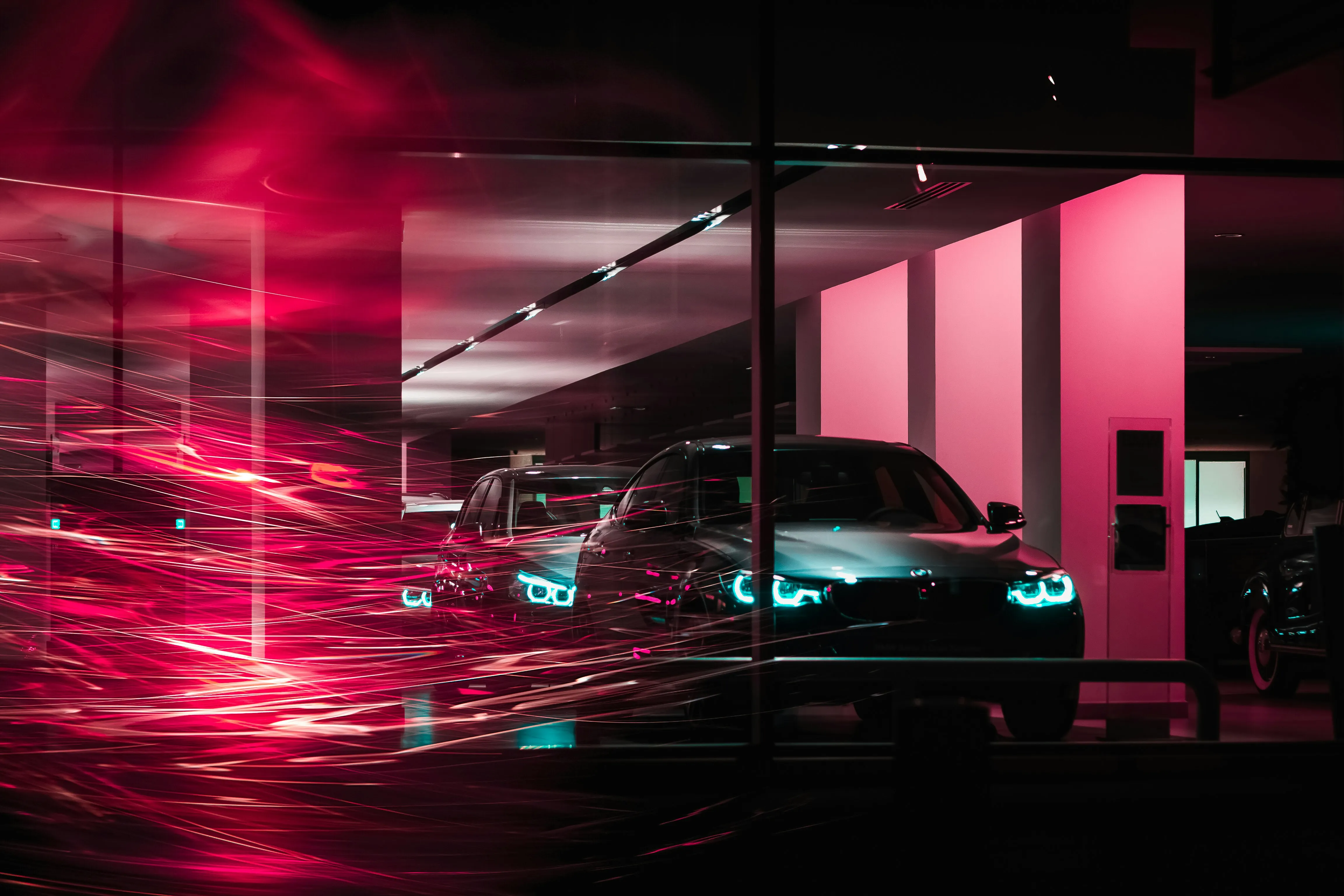 Luxury car showroom at night seen through a window